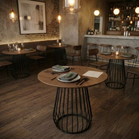 Close-up of curved black metal rods forming the base of a teak bistro table