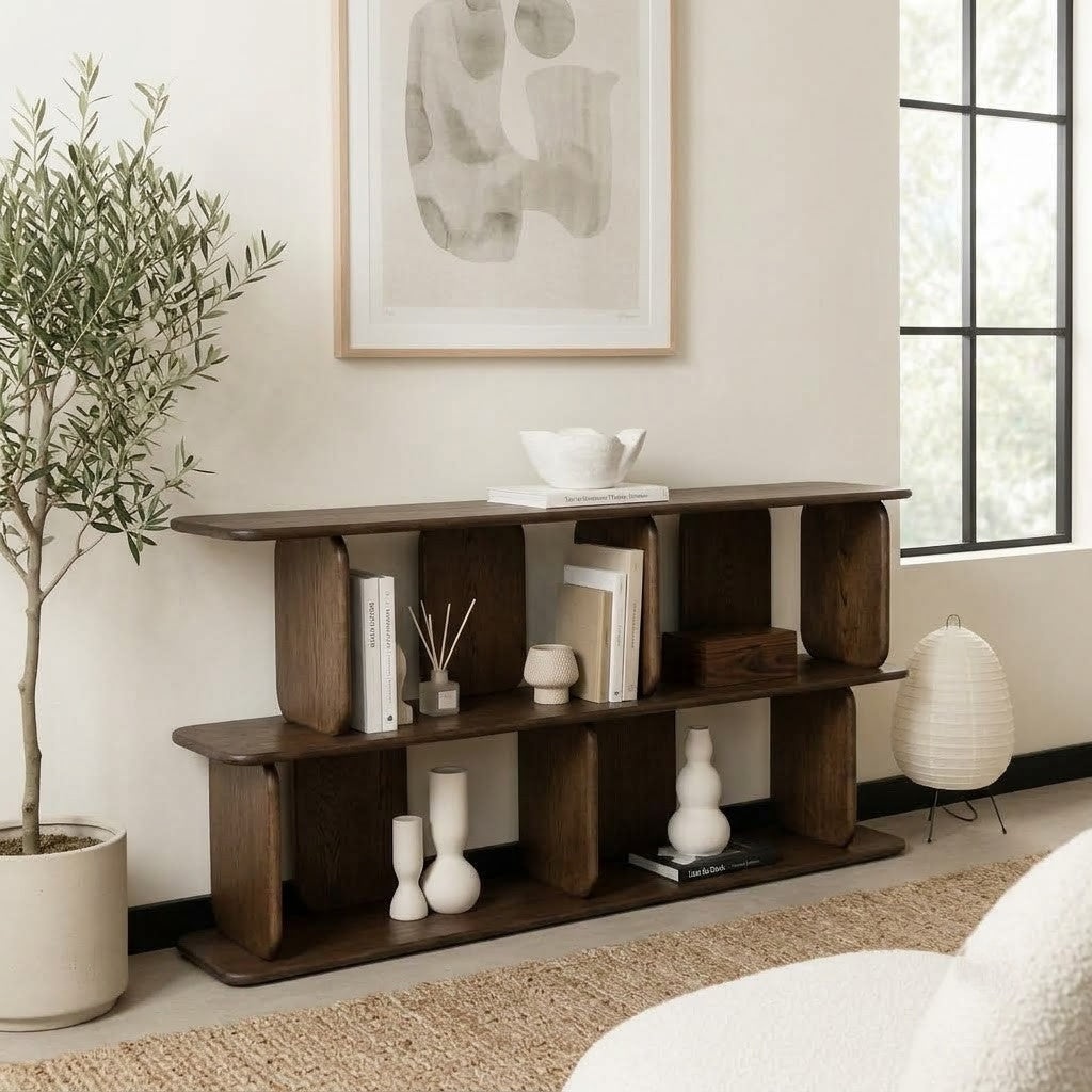 Dark wooden display shelf with sculptural rounded posts styled with books and ceramic vases