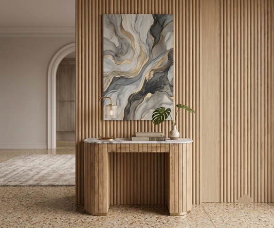 A contemporary console table featuring a rounded white marble top resting on a thick, light wood base with a vertical fluted texture. The table has an open-center silhouette, with its curved legs set on thin brass base plates.
